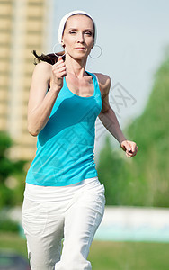 美丽的女子在绿色公园中奔跑运动活力女性女士精力环境季节森林慢跑者娱乐图片