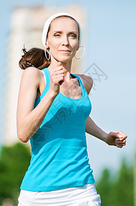 美丽的女子在绿色公园中奔跑慢跑女性幸福女士活力森林运动街道娱乐跑步图片