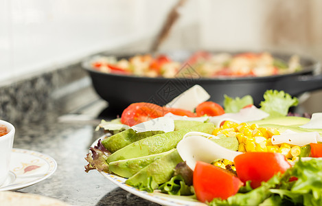 特写新鲜沙拉菜盘和女性在锅里做饭红色绿色食物蔬菜玉米平底锅胡椒玉米片洋葱沙拉图片