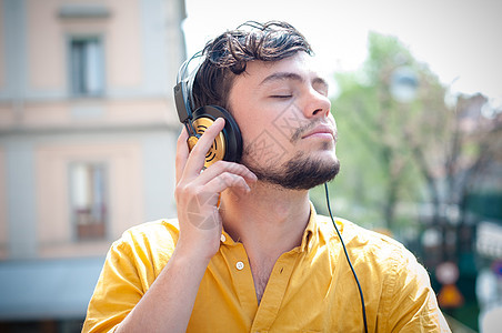 听音乐的青春青年乐趣年轻人黄色衬衫音乐耳机阳台城市图片