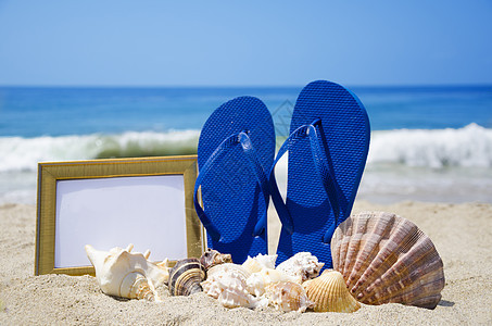 沙沙滩上带照相机和贝壳的滑坡拖鞋和贝壳假期木板海滩记忆相框蓝色框架照片旅游旅行图片