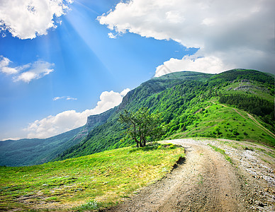 山区乡村公路山丘中的国家公路天空季节风景小路场地爬坡蓝色阳光太阳牧场图片
