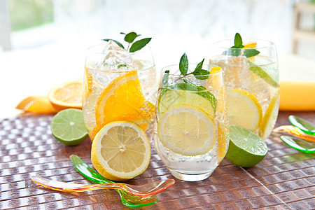 冷饮柠檬和橙子冰块玻璃薄荷树叶饮料勺子吸管蓝色水平果汁图片