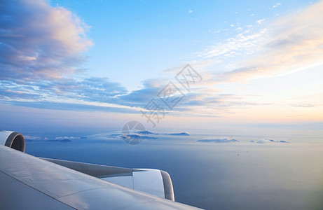 在蓝天飞行机翼飞行时通过窗式飞机看望地球晴天假期旅游太阳乘客航空涡轮技术机器图片