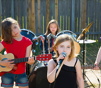 歌唱女歌手在后院现场演奏乐团草地孩子童年音乐会晴天唱歌玩家音乐蓝色女性图片