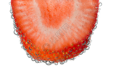 清风水泡泡背景中的草莓切片图片