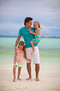 和两个女儿一起快乐的父亲 在热带沙滩度假时图片