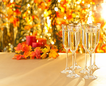 秋天背景前的香槟酒杯招待会用眼镜请柬长笛橙子金子魅力酒精白酒插花奢华树叶图片