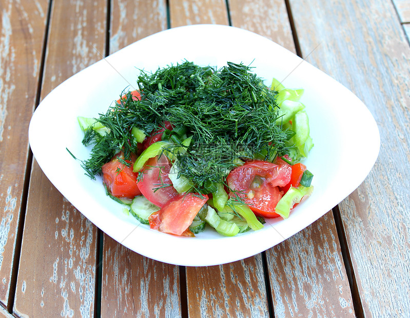 蔬菜沙拉在花园桌上的白盘子里绿色白色胡椒红色盘子洋葱辣椒桌子木头图片