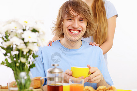 快乐的年轻人喝茶蓝色杯子厨房闲暇男人微笑男性生活幸福成人图片