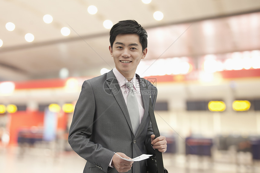 在中国北京机场持有机票的青年商务人士 营业执照 中国北京黑发衣冠运输幸福商业旅行摄影商务套装带子图片