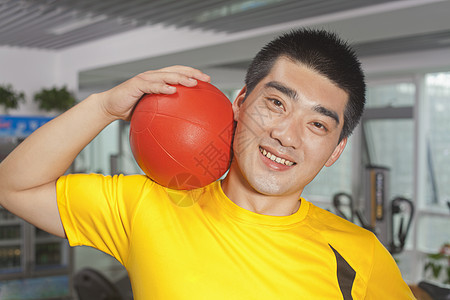 男人在健身房的肩膀上打球图片