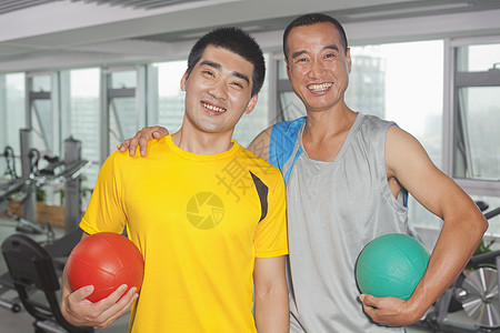 两个男人在健身房里拿着球图片