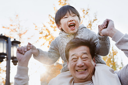 祖父肩上背着格兰德森黑发拥抱休闲孙子退休活动保暖季节摄影享受图片