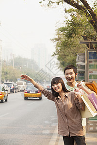年轻夫妇带着购物袋 在北京搭乘出租车服装摄影公交街道休闲年轻人衬衫活动海陵旅行图片