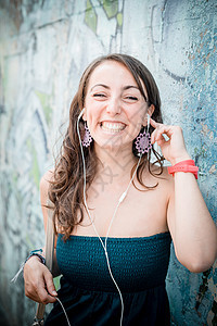 听音乐的美容女子女士音乐播放器音乐微笑放松城市耳机幸福街道图片