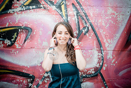 听音乐的美容女子耳机音乐街道音乐播放器城市微笑女士幸福放松图片
