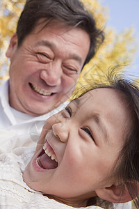 祖父和外孙女在公园玩耍童年微笑家庭退休乐趣活动摄影幸福喜悦季节图片