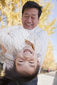 祖父和外孙女在公园玩耍喜悦俏皮季节团结乐趣亲热家庭退休童年情绪图片