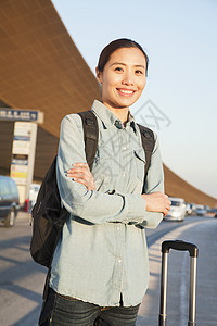 机场外年轻旅行者肖像棕色飞机场双臂长度旅行女性自由休闲摄影旅游图片