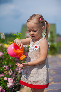 可爱可爱的可爱女孩 用水罐子浇鲜花生活爱好花园金发场地孩子院子植物学园艺牛仔裤图片