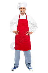 放松的厨师站在他的腰上快乐围裙手势男人服务酒店厨房餐厅商业食谱图片