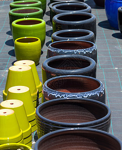 市场上的多彩陶瓷锅集装箱棕色红色制品橙子店铺花瓶花园陶器花盆图片