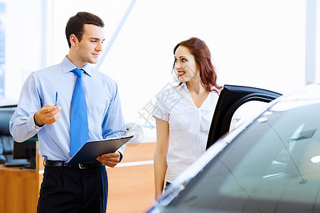 在汽车沙龙的年轻女子客户零售顾问商业销售销售员服务驾驶成人车辆图片