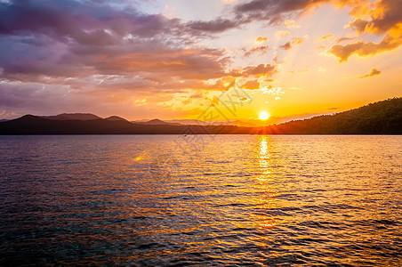 环绕湖面的风景峡谷远足树木骑手远景太阳丘陵反射蓝色日落图片