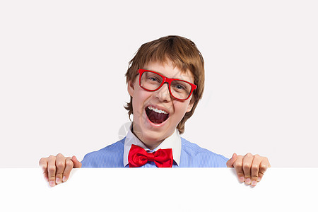 红色戴红眼镜的男孩持有白方男性教育童年学生海报眼镜标语领结微笑手臂图片