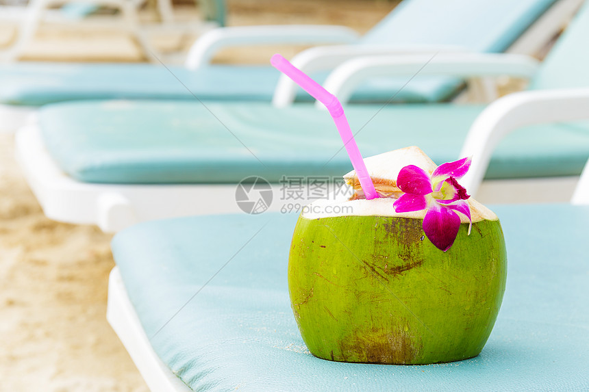 日光浴和椰子饮料果汁晴天休息室时间闲暇稻草绿色长椅粉色座位图片