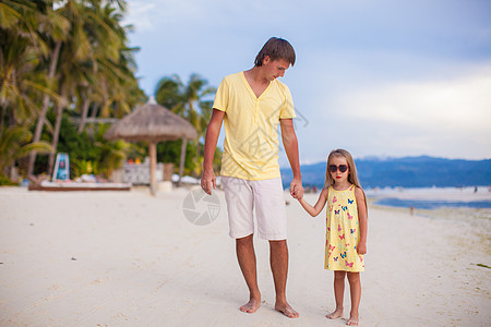 和他可爱的女儿一起快乐的父亲 在热带沙滩度假时散步图片