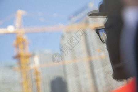 玻璃建筑特写建筑师在建筑工地的倒影进步眼镜人脸城市生活玻璃安全帽起重机反射部位承包商背景