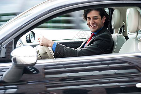 公司的人驾驶他的车老板套装内饰交通方向盘管理人员雇主快乐安全人士图片