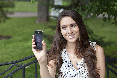 快乐的年轻女士 在你的手机上拍照女性成人微笑戒指白色细胞电话喜悦相片黑发图片