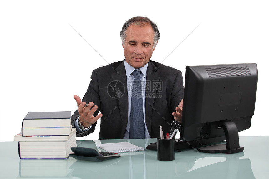 在他的办公桌工作的商务人士笔记本男人头发桌子套装人士场地困惑技术男性图片