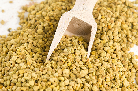 木勺中的蜜蜂花粉 营养补充品食物橙子颗粒剂蜂蜜玻璃粮食种子烹饪药品面包图片