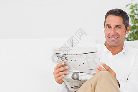 微笑的人在看报纸沙发白色男性媒体客厅房子印刷阅读男人家庭衬衫高清图片素材