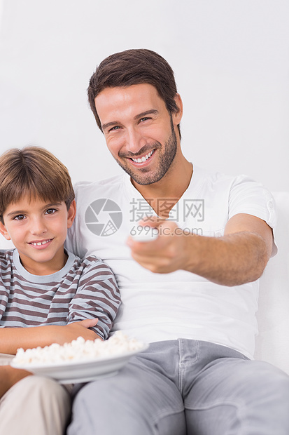 父亲和儿子笑着看电视图片