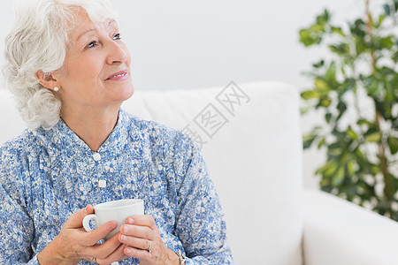 笑着微笑的老年妇女向远方看背景图片