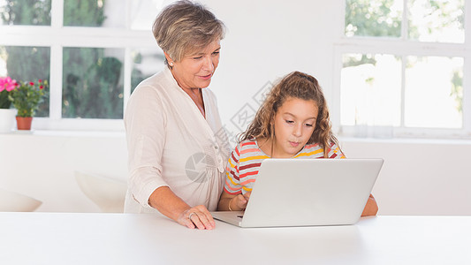 祖母和孩子一起看笔记本电脑图片