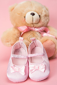 粉红婴儿靴和泰迪熊图片