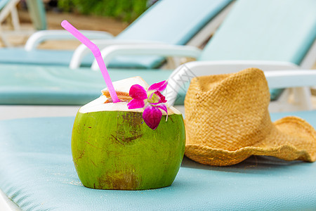 在海滩上放松日光浴果汁椰子长椅稻草闲暇晴天座位绿色帽子图片