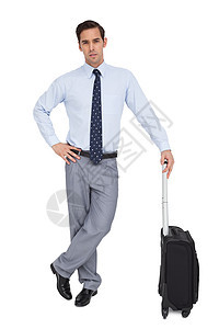 英俊的商务人士拿着手提箱站着游客旅行人士领带倾斜衬衫商业行李男人公司图片