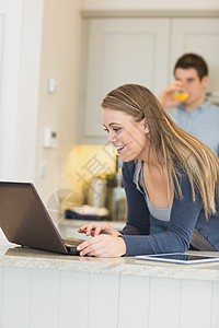 女人通过网络摄像头和男人聊天 喝橙汁图片