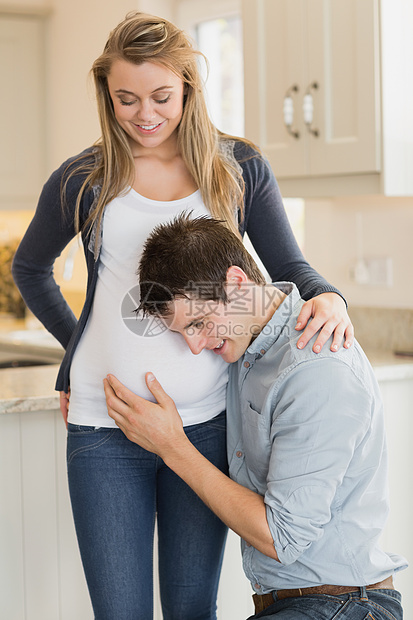 听孕妇胃部的男子;图片