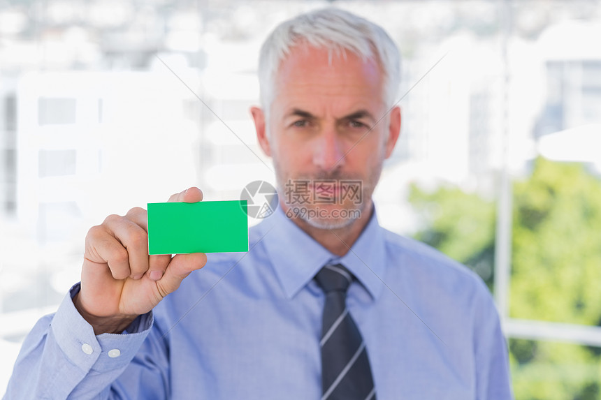 展示绿色名片的商务人士图片