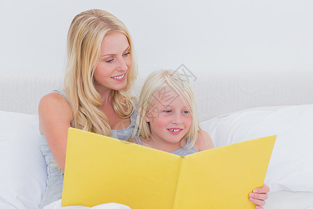 妈妈读一个故事给女儿听头发房子阅读亲密感情怀女士枕头孩子女孩长发图片