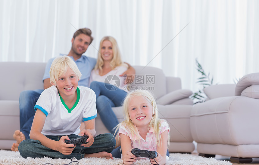 儿童坐在地毯上玩电子游戏的儿童人数图片