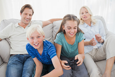 儿童在沙发上玩电子游戏图片